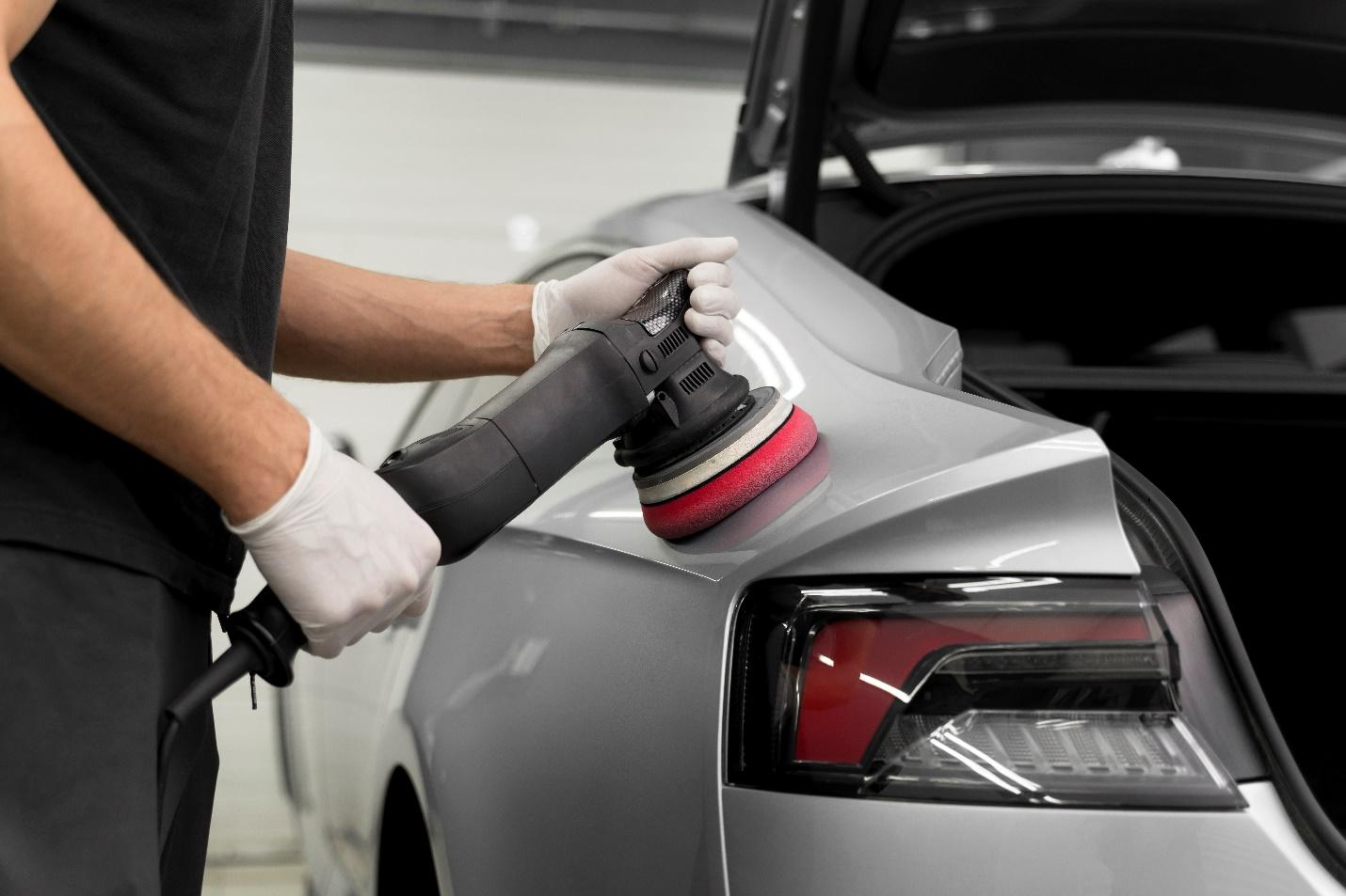 A person buffing a silver grey car
